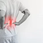 Office syndrome, Backache and Lower Back Pain Concept. a man touching his lower back at pain point